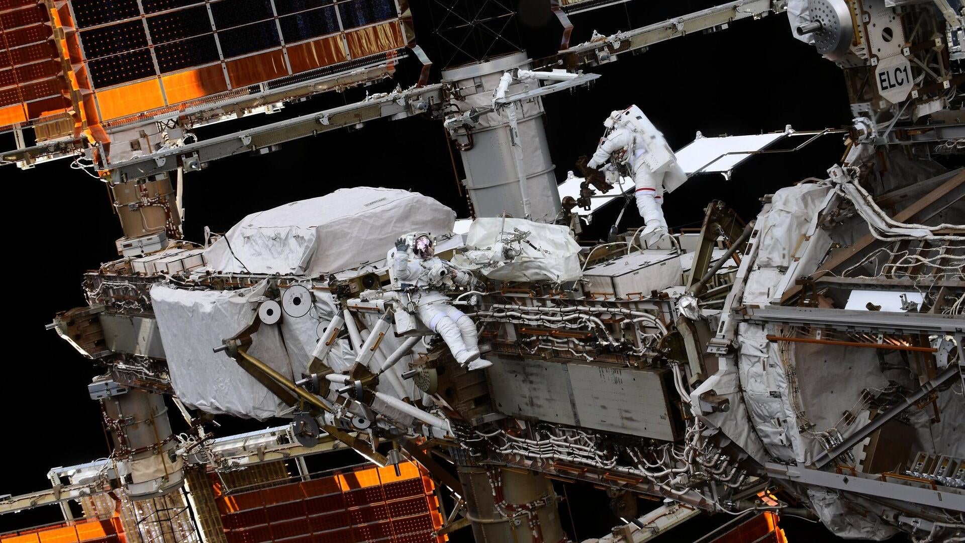 ESA astronaut Thomas Pesquet and JAXA astronaut Aki Hoshide performing a spacewalk outside the ISS.