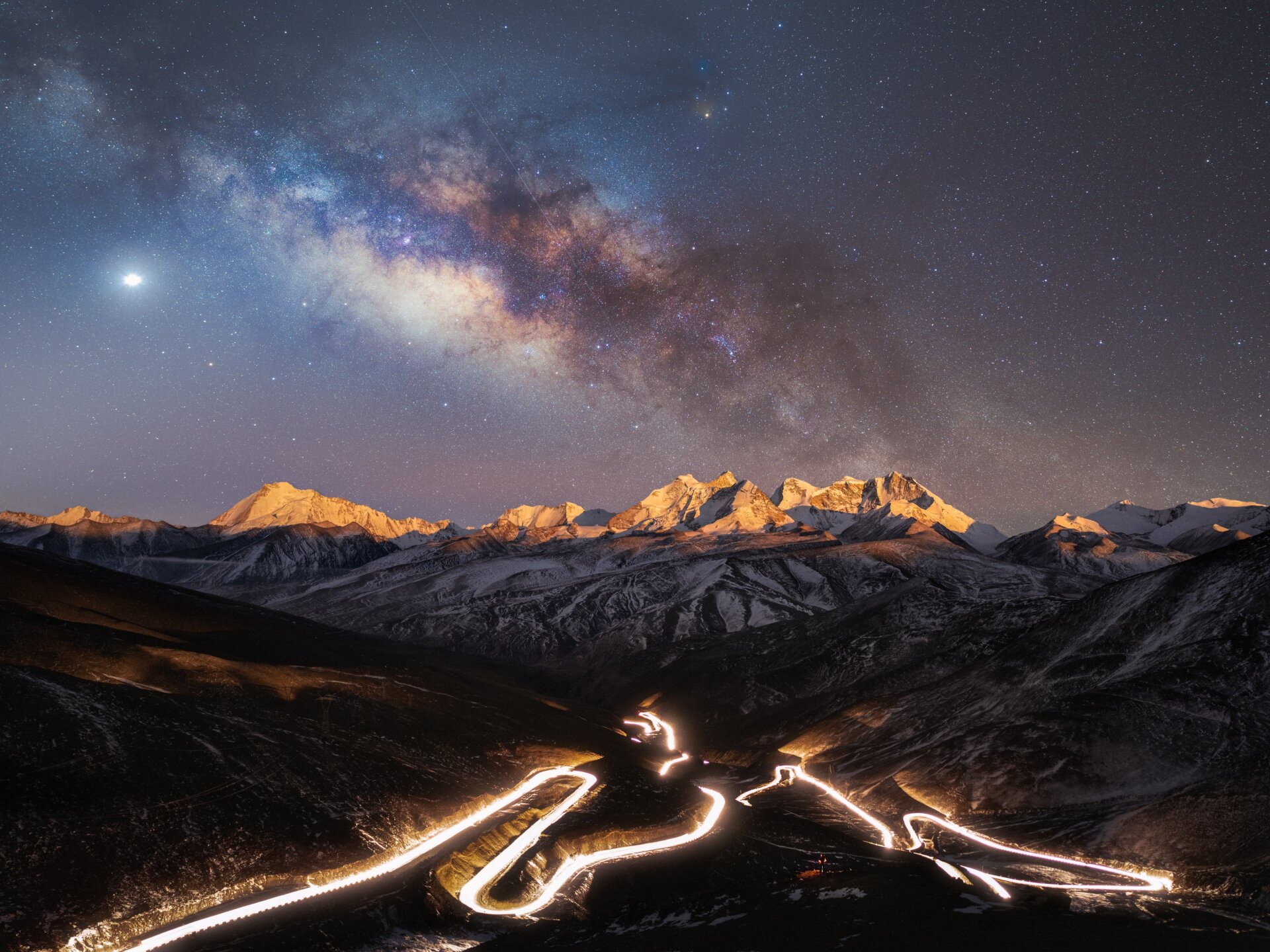 The Milky Way over the mountains and a highway.