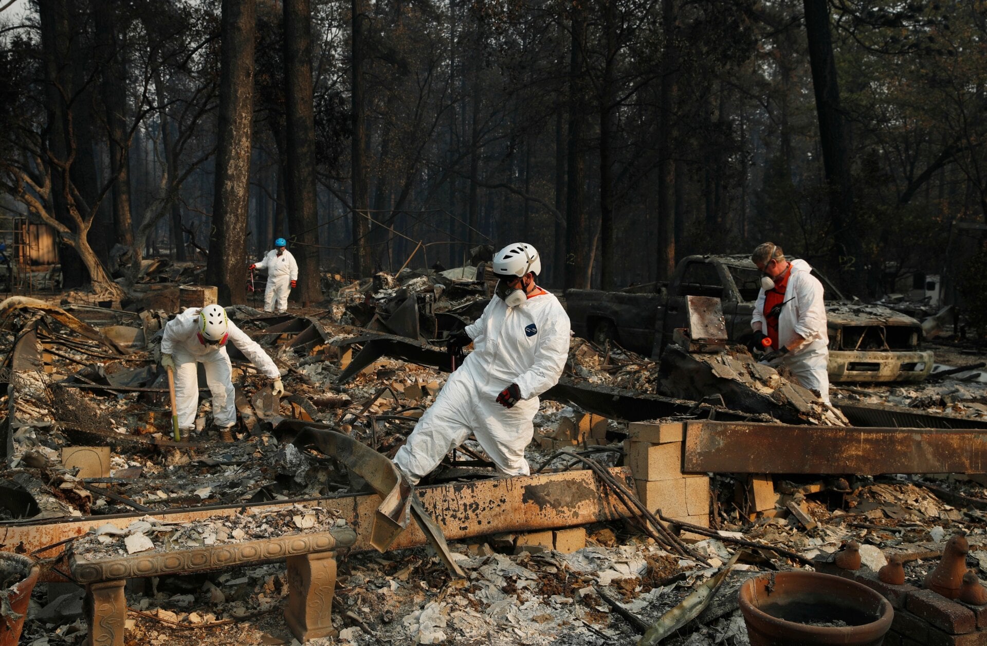 After the 2018 Camp Fire, rescue workers search for human remains among the rubble.