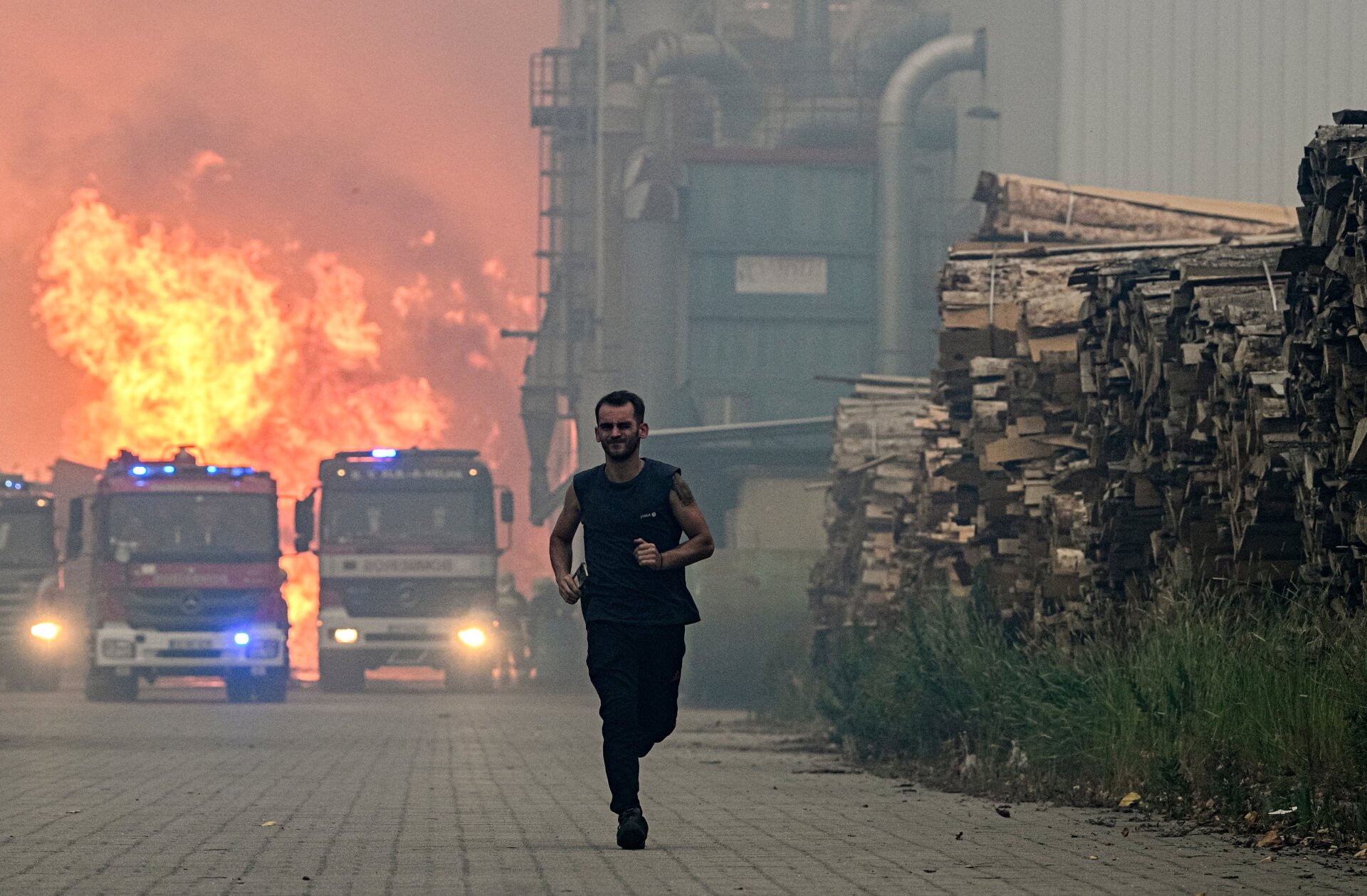 A lumber factory worker runs from a fire that hit his factory in Albergaria a Velha, Portugal on July 13, 2022. 