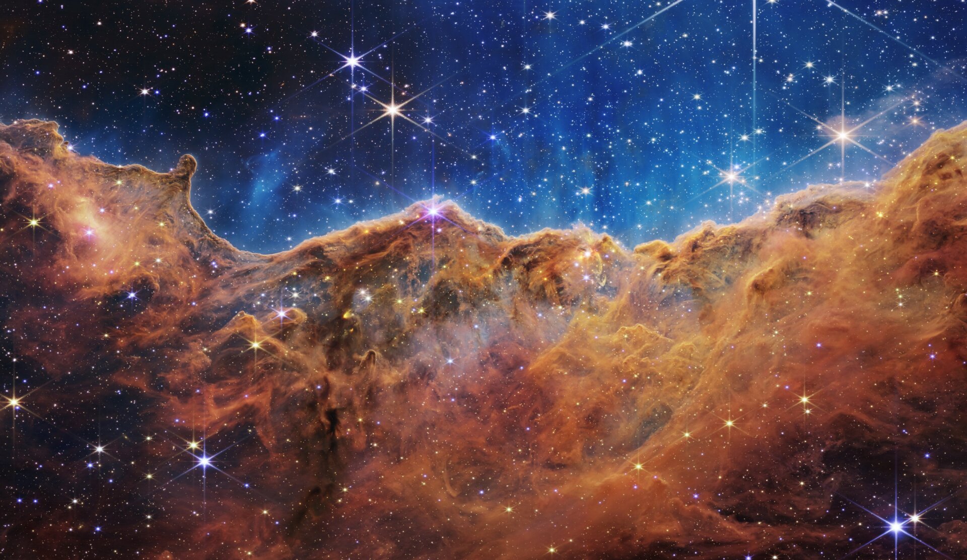 The “Cosmic Cliffs” of the Carina Nebula seen by Webb in infrared.