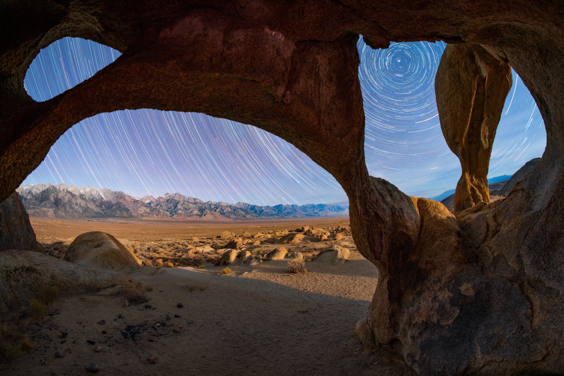 A swirl of stars outside a stone structure in the California desert.