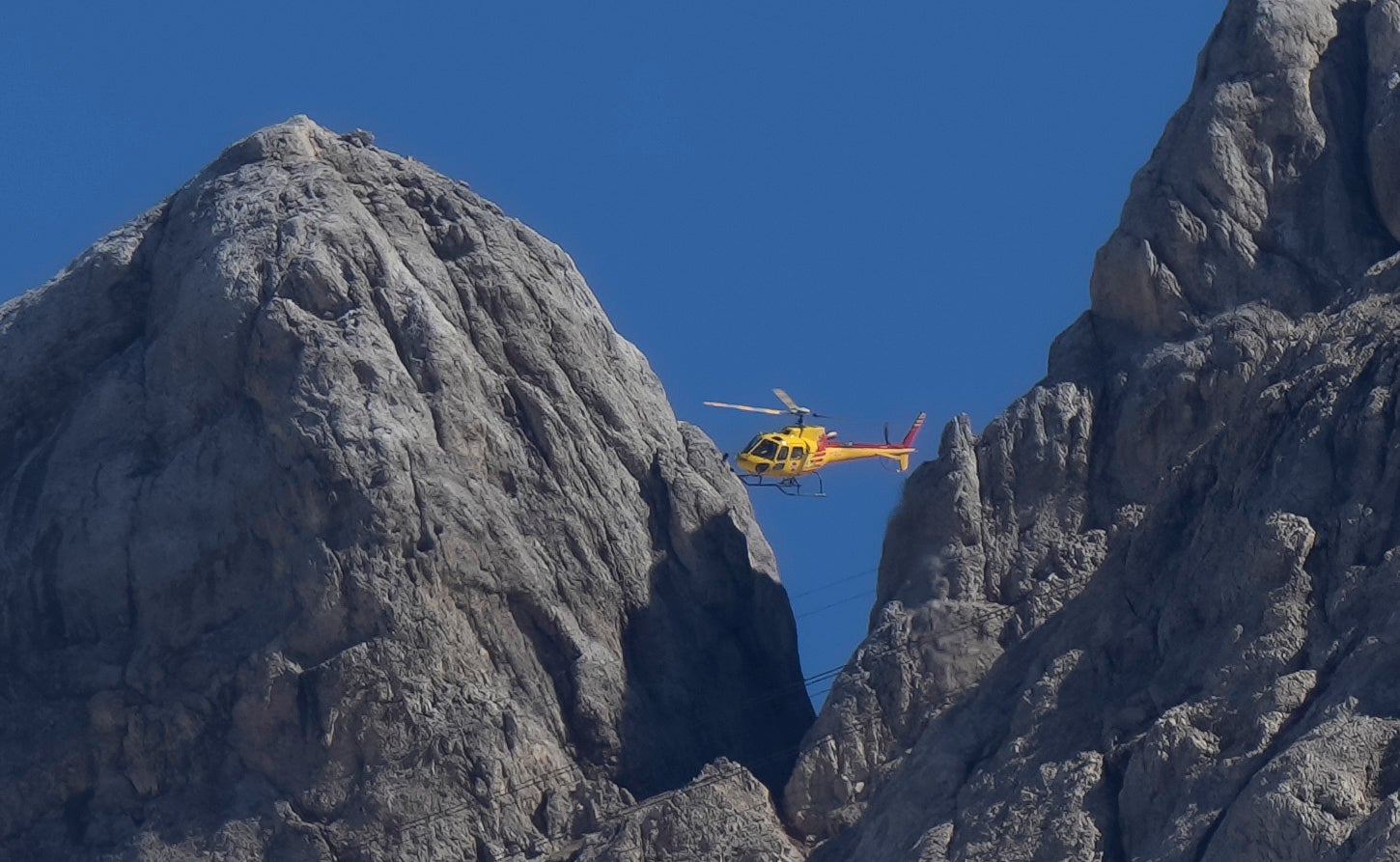 A helicopter searches for survivors. 