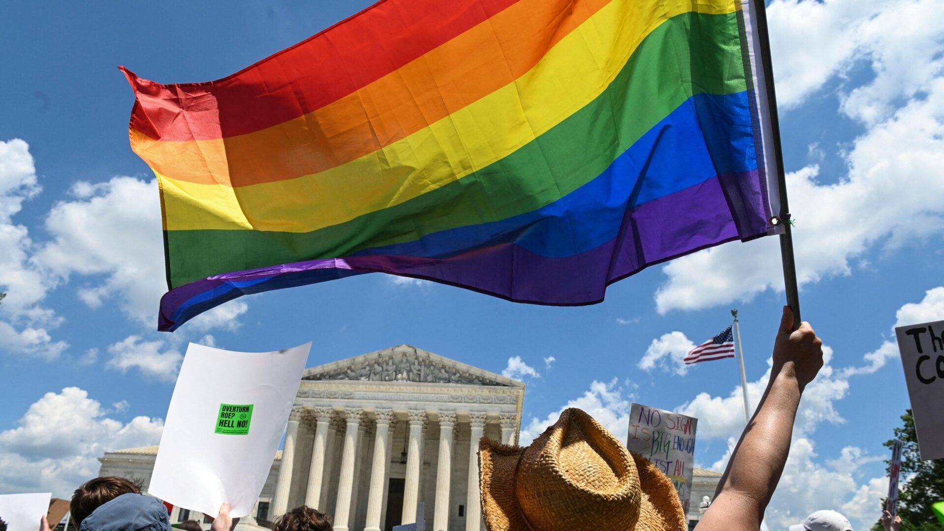 Protesters wave a Pride flag in front of the Supreme Court a day after the Court struck down Roe v. Wade.