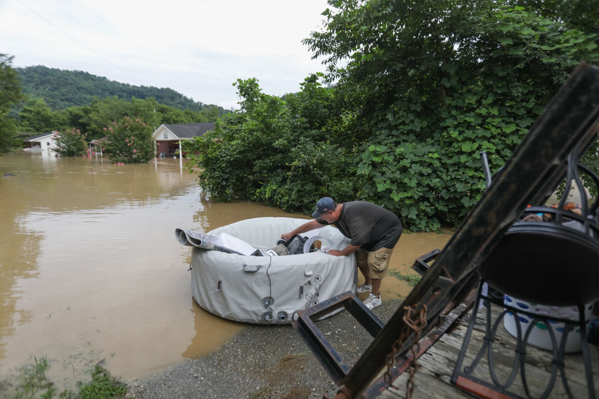 A man loads possessions into a floating device into waters around his home in Jackson. 