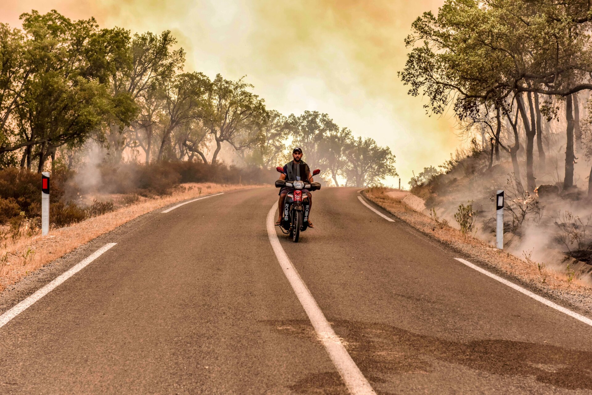 A man drives through a burning forest in Larache, northern Morocco, Friday, July 15, 2022.