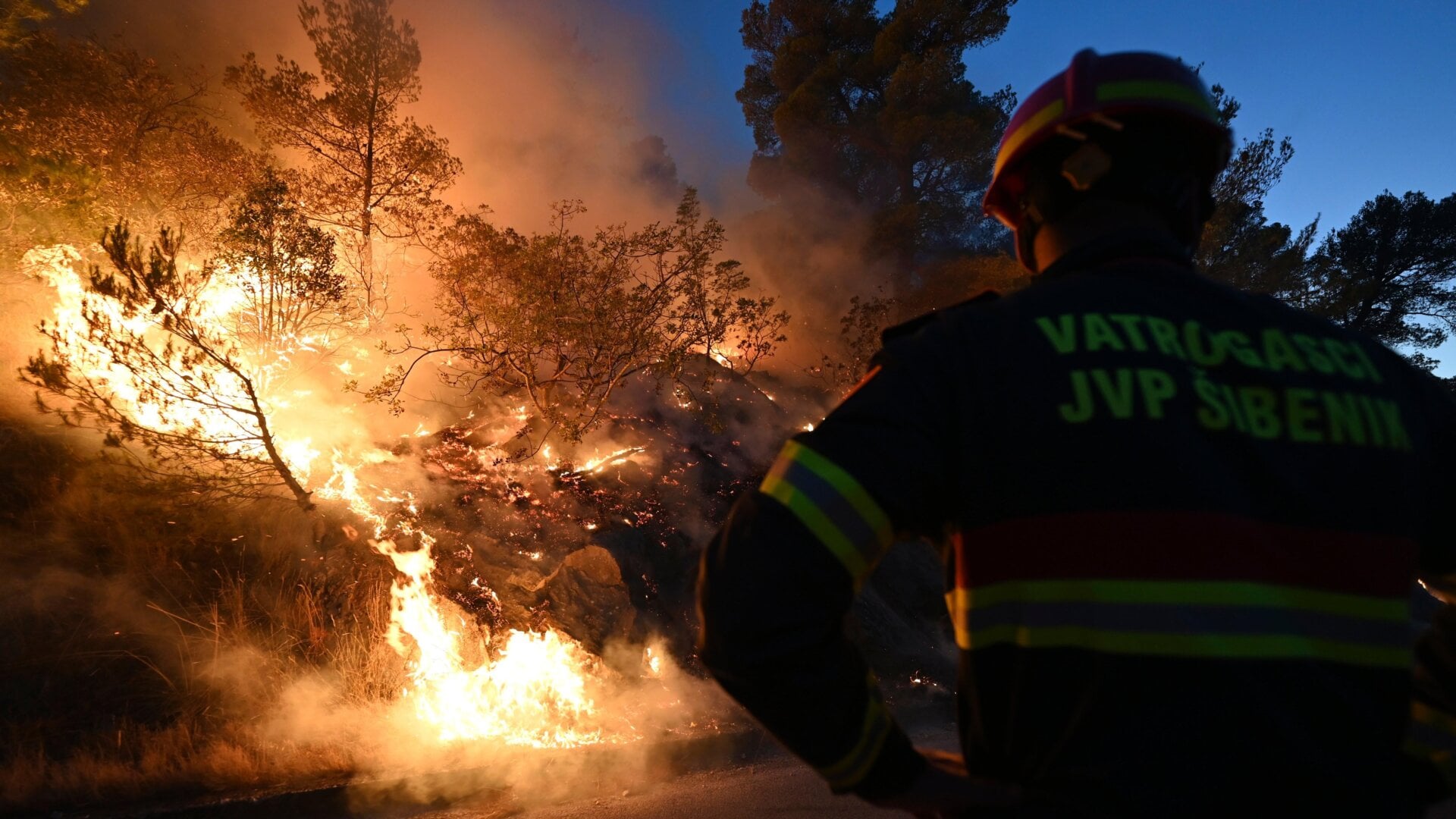 A firefighter battles a blaze in Zaton, Croatia, on Wednesday, July 13, 2022.