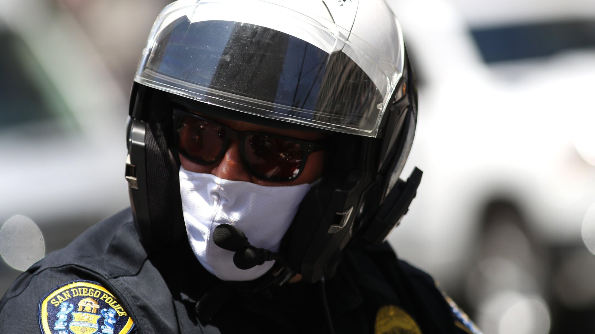 A San Diego Police Department officer looks on as activists hold signs and protest the California lockdown due to the coronavirus (COVID-19) pandemic on May 01, 2020 in San Diego, California.