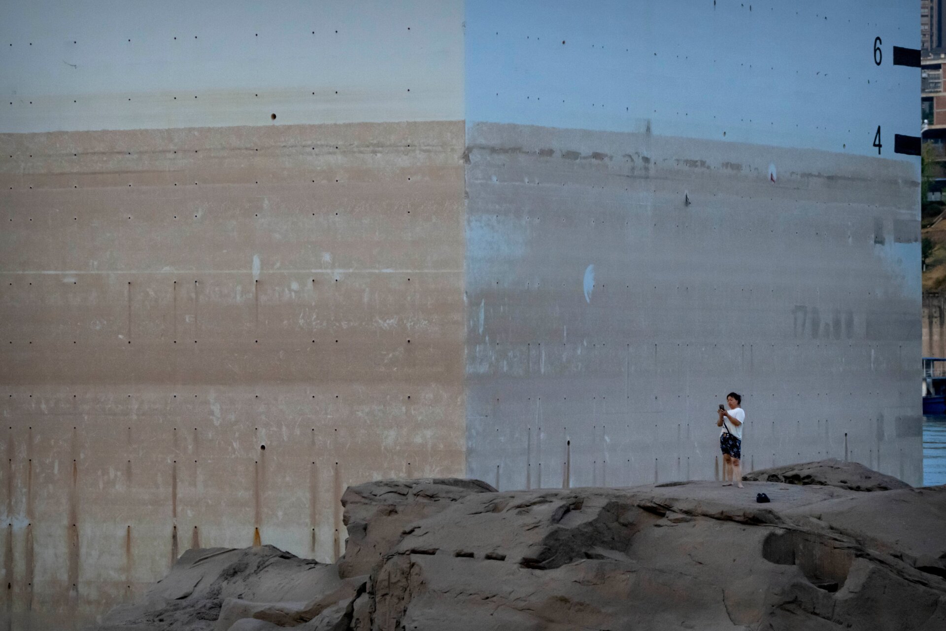 A woman takes a photo on the low Yangtze in Chongqing on August 19.