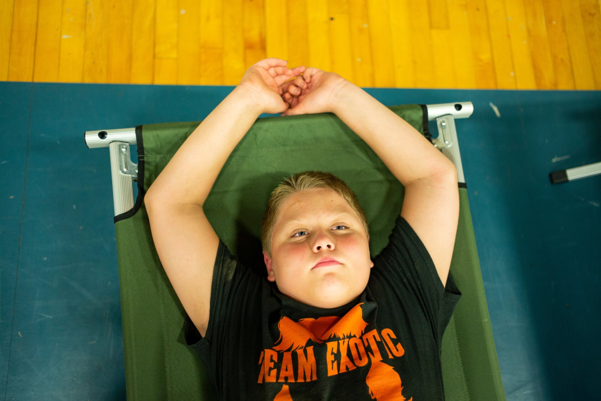 Zachary Stivers, 11, of Lost Creek, Kentucky, rests on a cot in the  Hazard Community & Technical College, where survivors of the major  flooding in Eastern Kentucky are being taken for shelter on July 28,  2022 in Breathitt County, Kentucky. 