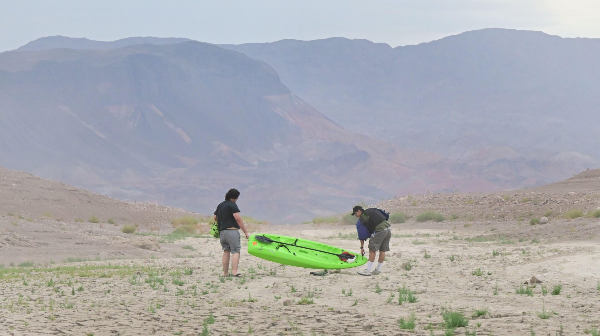 People carry a boat over land once covered in water at Lake Mead, Nevada on July 23, 2022.