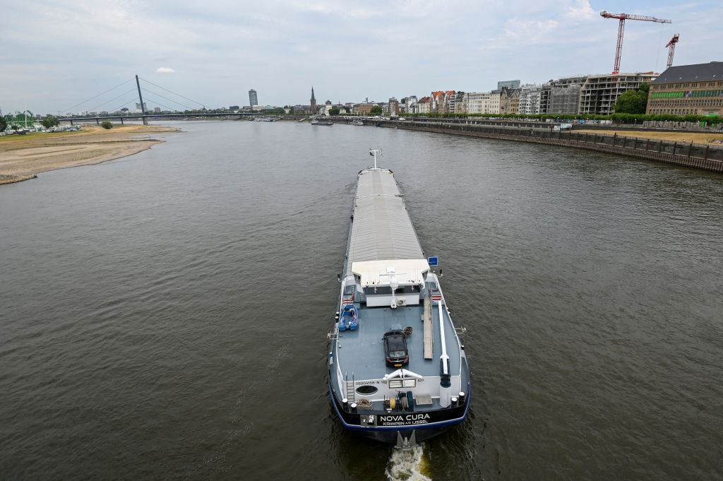 An inland vessel navigates on the Rhine as the partially dried-up river bed is seen in Duesseldorf, Germany, in late July as Europe experiences a heatwave. 