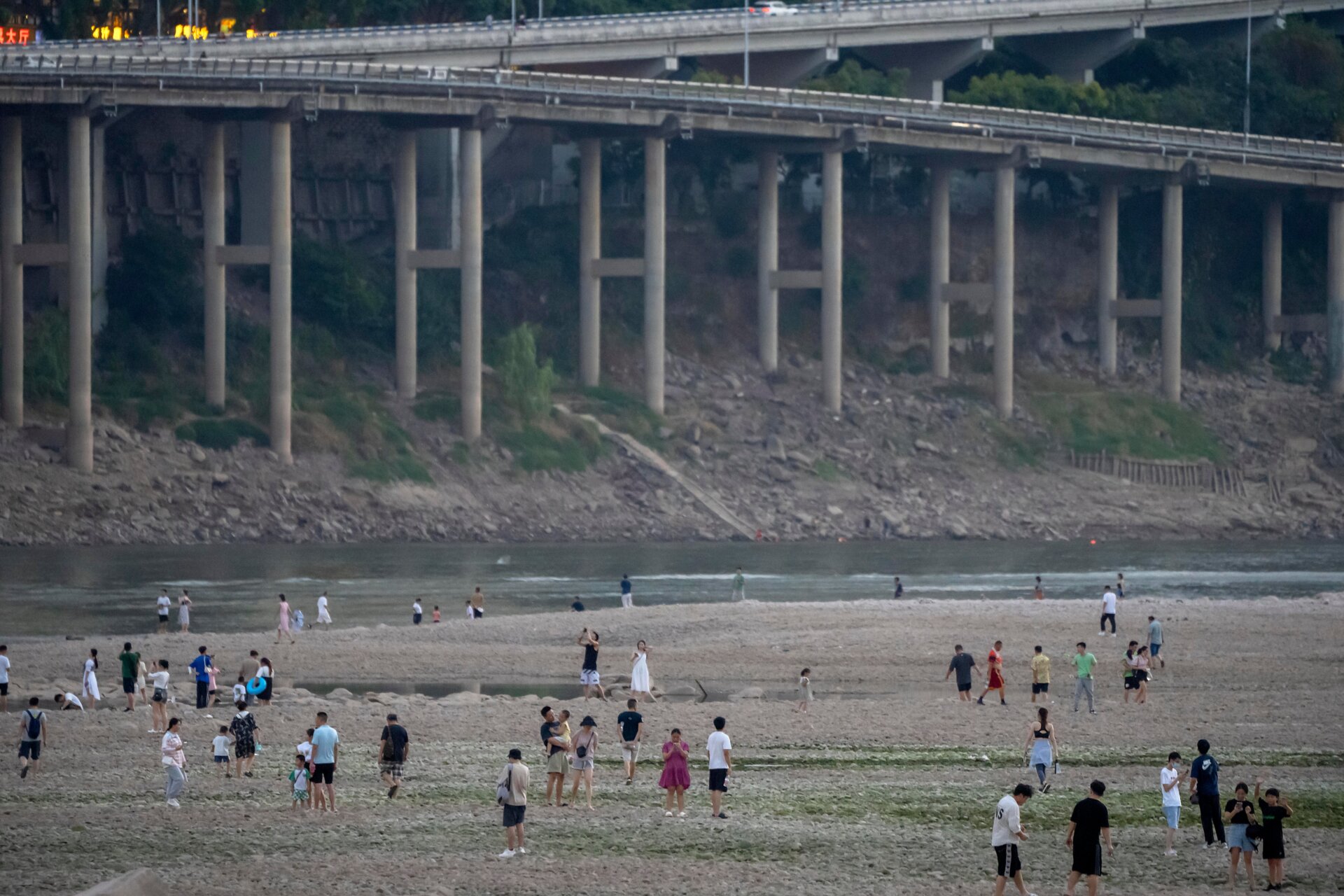 People walk in the dry riverbed of the Jialing River, a tributary of the Yangtze, on August 20.
