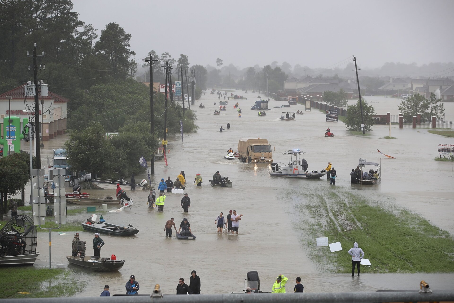 People walk down a flooded street as they evacuate their homes after the area was flooded during Hurricane Harvey on August 28, 2017 in Houston, Texas.