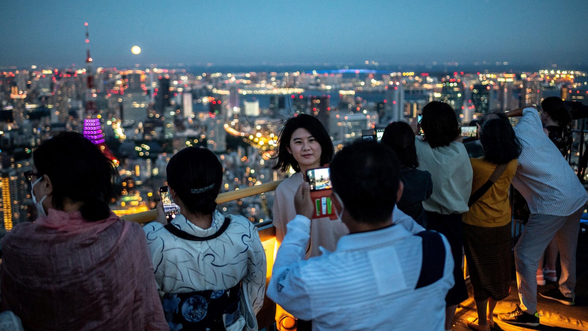 People watch the full moon on the observation deck of Roppongi Hills 
Mori Tower, during a harvest-moon viewing event in Tokyo on September 
10, 2022.