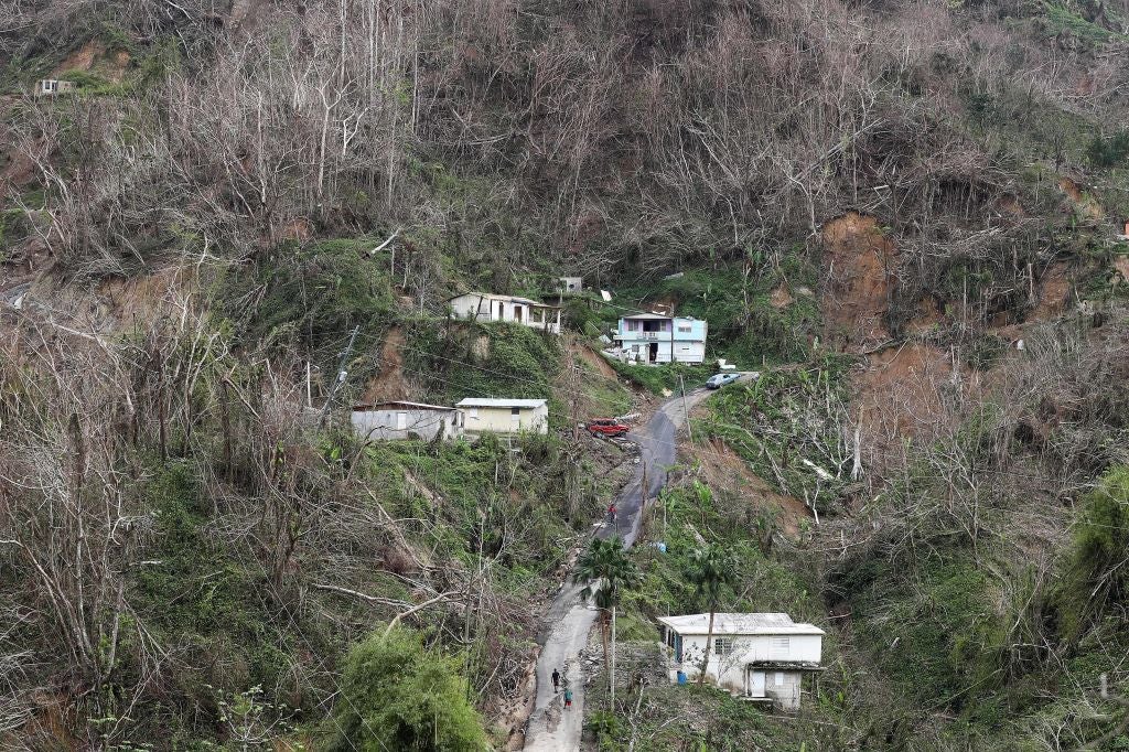 Community members walk on the street in a devastated section nearly three weeks after Hurricane Maria hit the island, on October 10, 2017 in Pellejas, Puerto Rico. They said they have received virtually no governmental assistance and their houses have no electricity or running water. 