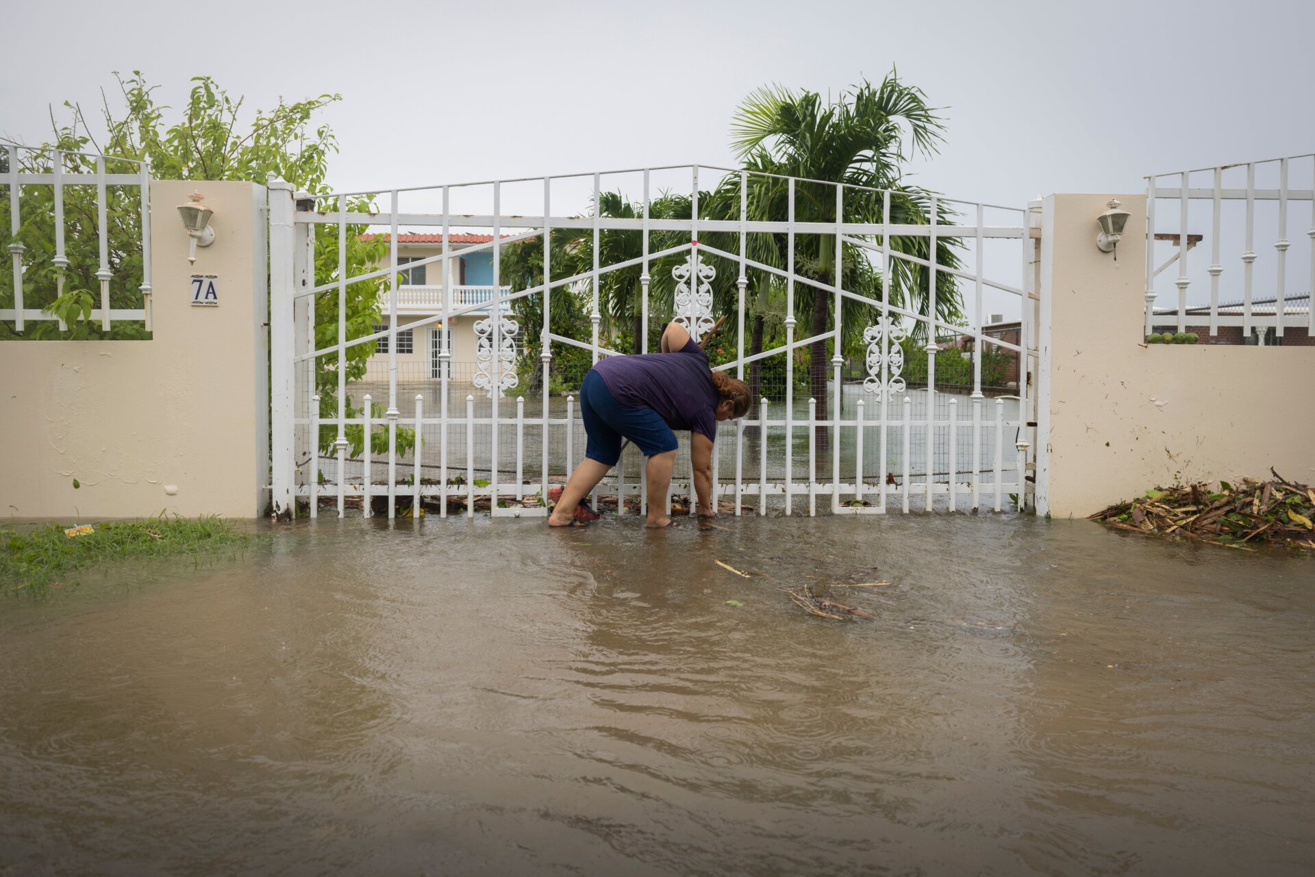 In Salinas, Puerto Rico, a woman attempted to clear debris from her property on Monday.
