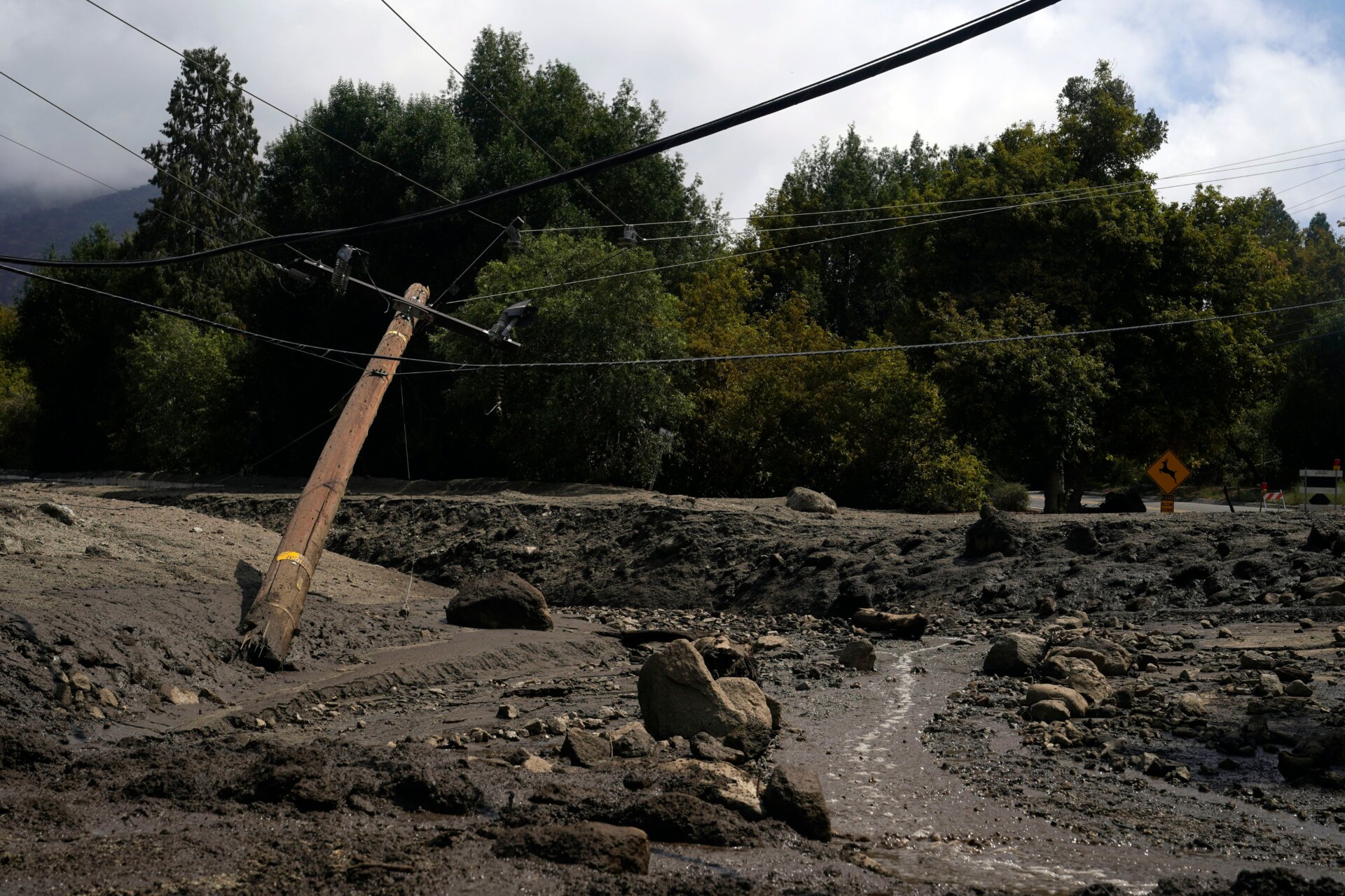 Electric poles are seen half-fallen in the aftermath of a mudslide on Tuesday, Sept. 13, 2022, in Oak Glen, California.