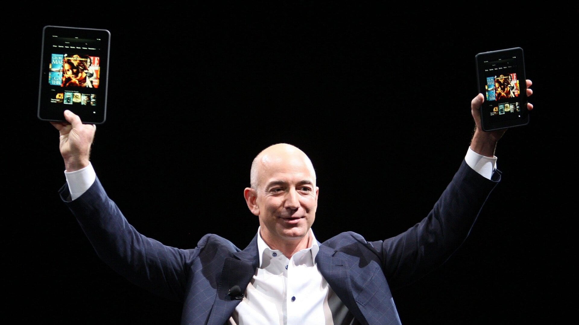 Amazon CEO Jeff Bezos holds up two Kindles at a press conference in 2012. The ebook reader was originally released in 2007.