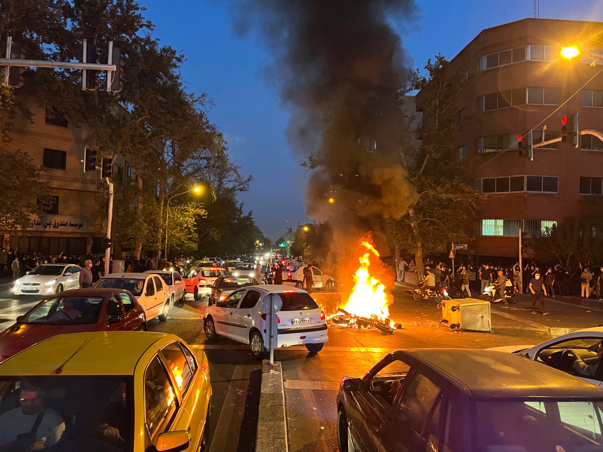 In this Monday, Sept. 19, 2022, photo taken by an individual not  employed by the Associated Press and obtained by the AP outside Iran,  anti-riot police arrive to disperse demonstrators during a protest over  the death of a young woman who had been detained for violating the  country’s conservative dress code, in downtown Tehran, Iran.