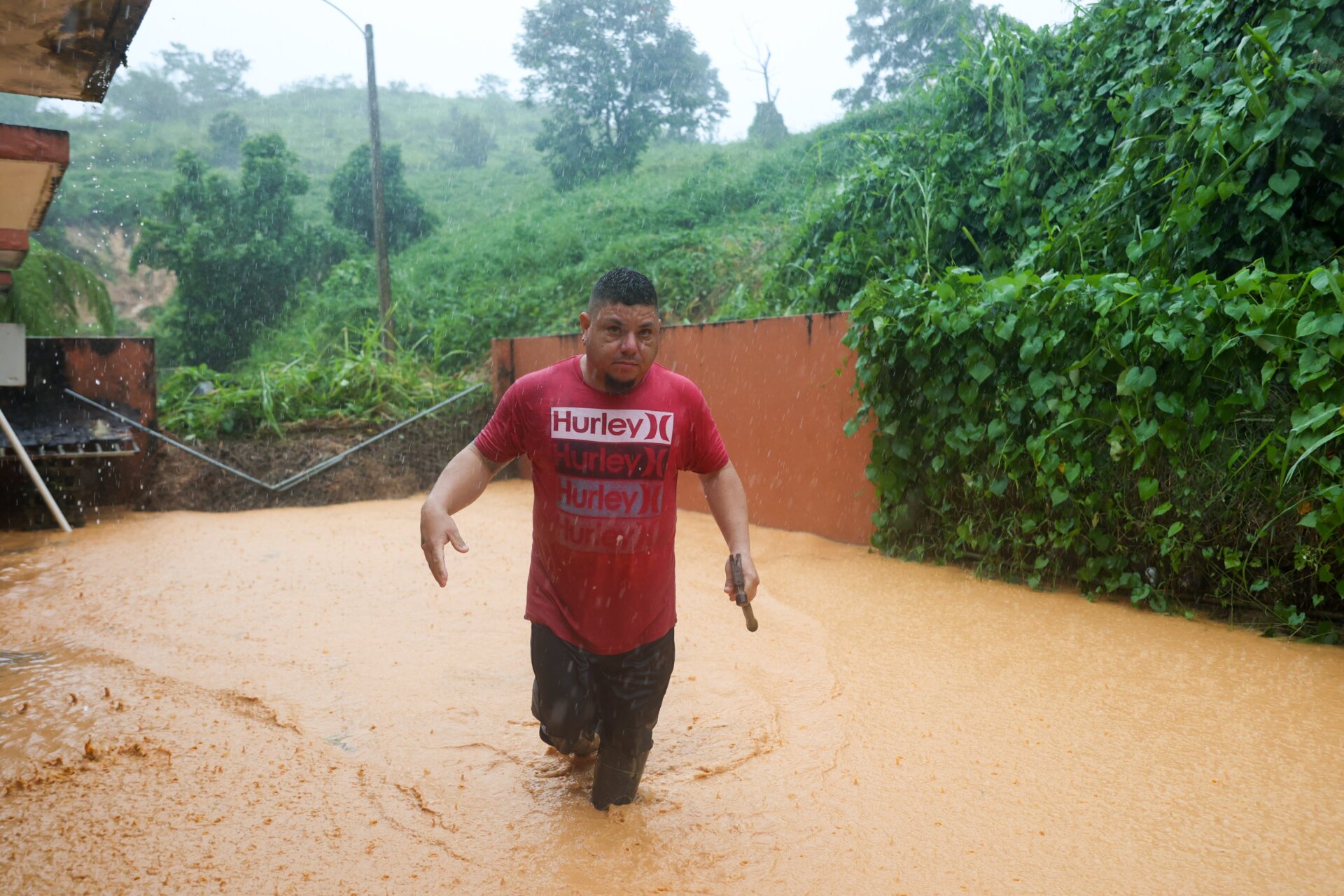 From AP: “A man walks on a road flooded by Hurricane Fiona in Cayey, Puerto Rico.” Several major roads across the island remain closed.