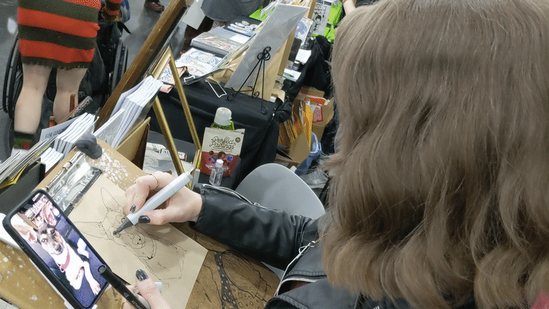 K. Lynne Smith talks about the difficulties of doing art while surrounded by people at a convention.