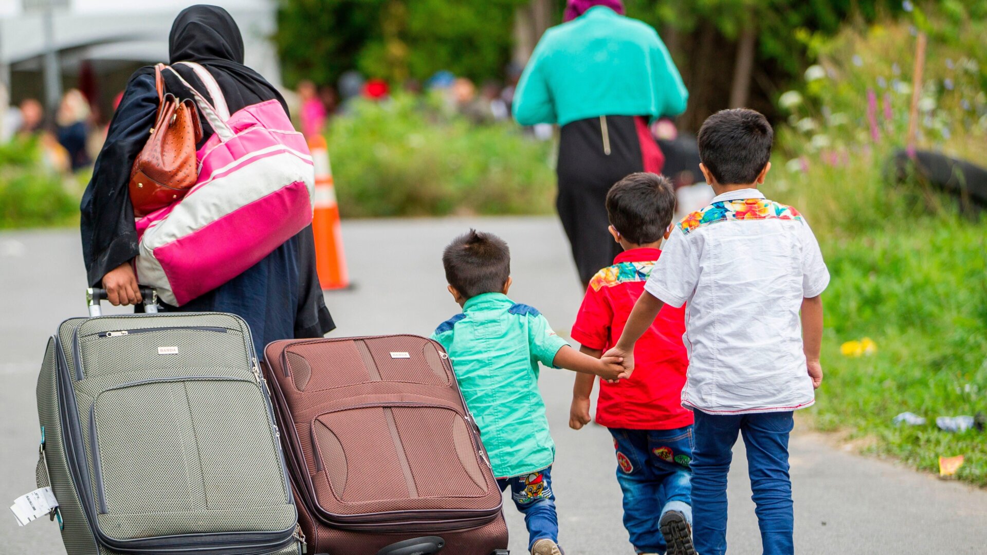 Asylum seekers walk along Roxham Road near Champlain, New York on August 6, 2017, making their way towards the Canada/US border.
