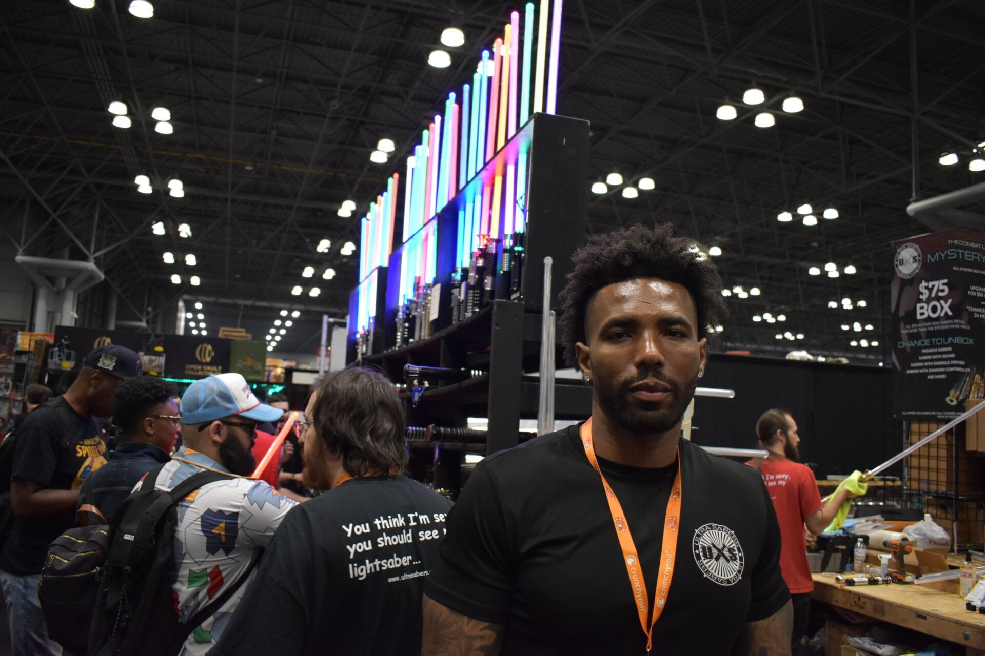 Emory Harris, the owner of Ultrasabers, stands in front of the busy booth at New York Comic Con.
