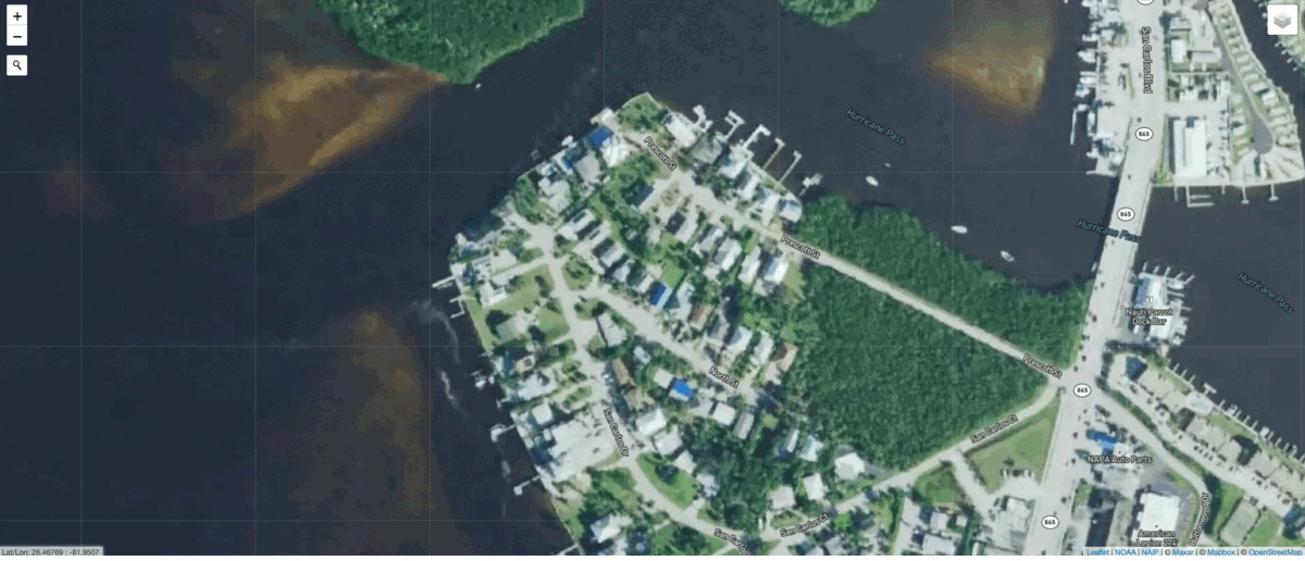 Houses in a neighborhood on San Carlos Island are still standing, with their roofs intact. However, surrounding debris left by the storm signals possible damage.