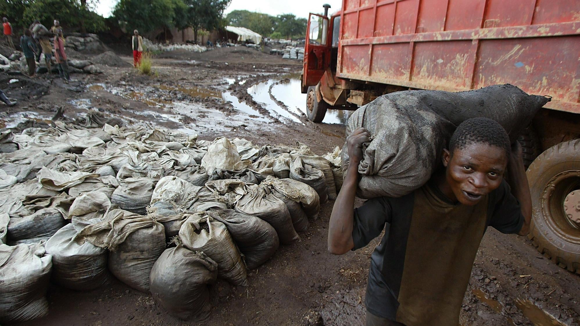 A worker carries wet cobalt at the Shinkolobwe Cobalt mine in the Democratic Republic of Congo.