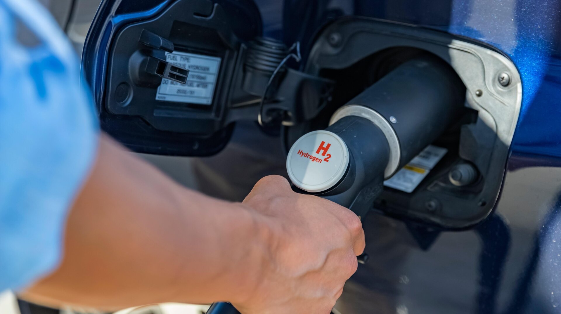 Fueling a car with hydrogen fuel.