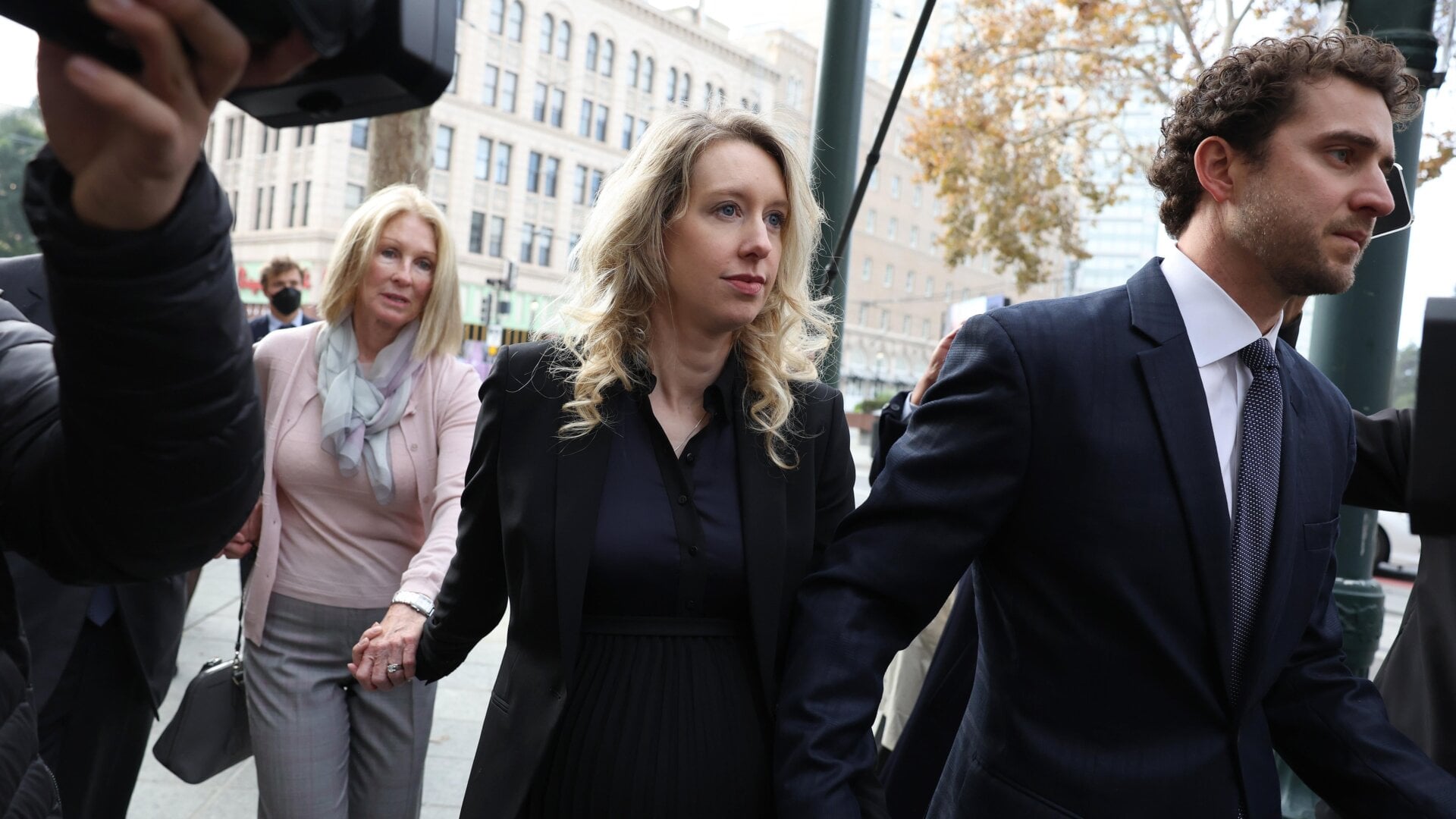 Theranos CEO Elizabeth Holmes, center, walking into court surrounded by her mother Noel Holmes and partner Billy Evans. Holmes was sentenced in San Jose Federal Court Nov. 18.