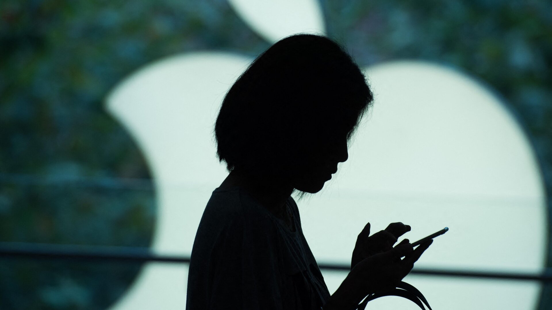 A customer uses her new smartphone during the release of the iPhone 6s at an Apple store in Shanghai on September 25, 2015.