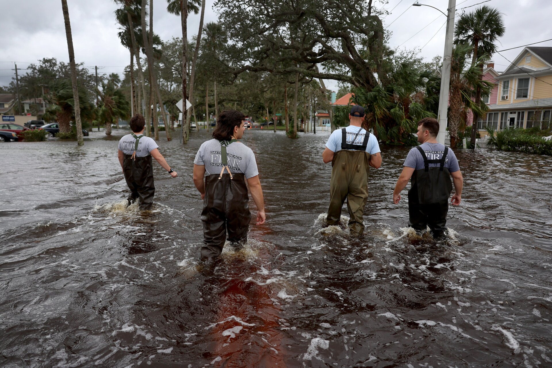 Daytona Beach Fire Department members wade through floodwaters searching for people in need of help. 