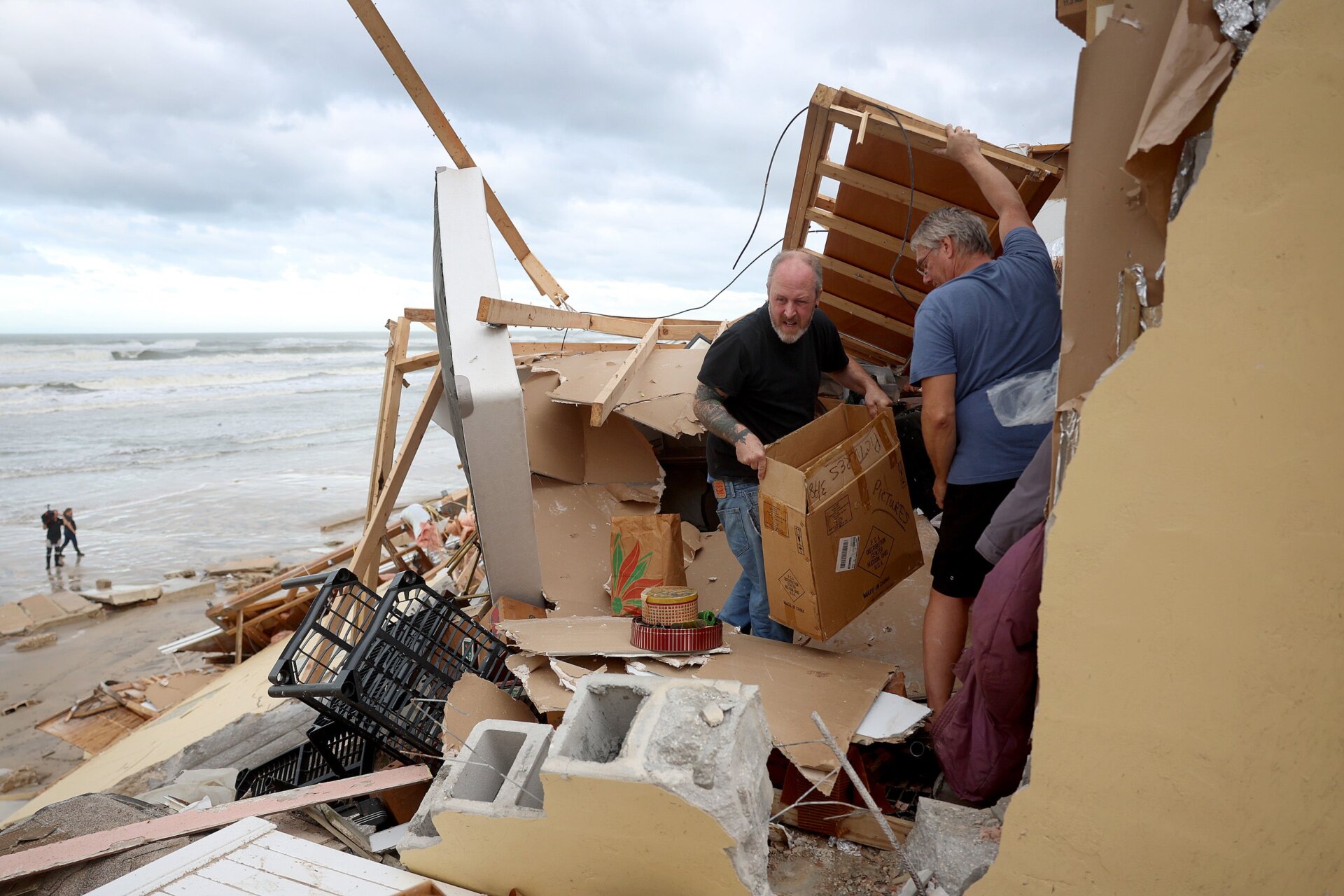 Clean-up efforts have already begun and neighbors help Nina Lavigna salvage what she can from her home in Daytona Beach.