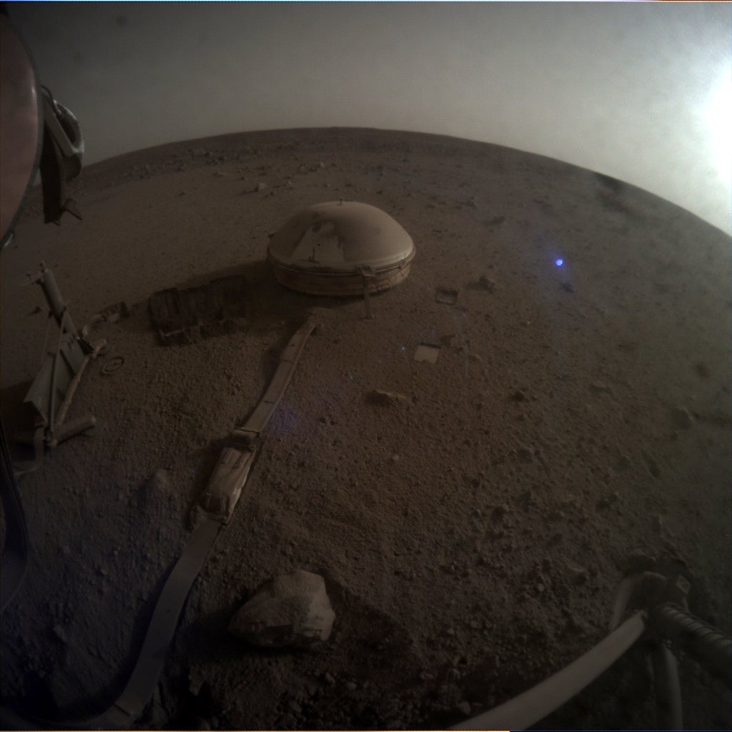 An image taken by InSight on May 4, 2022, the day of the quake. The seismometer—covered in dust—is visible at center.