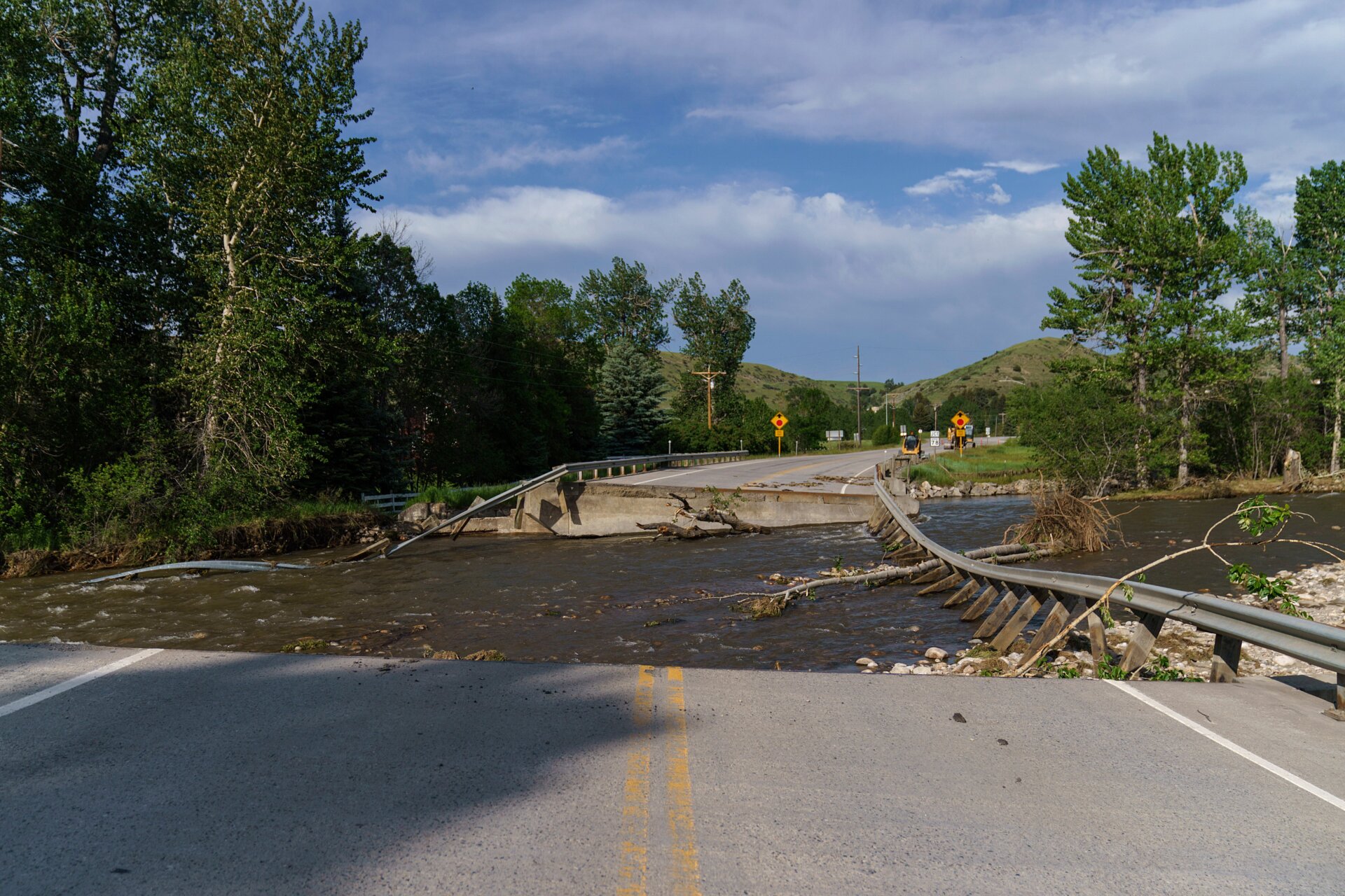 A river flows through a missing section of a key bridge that leads to the tourist town of Fishtail, Montana. Friday, June 17, 2022.