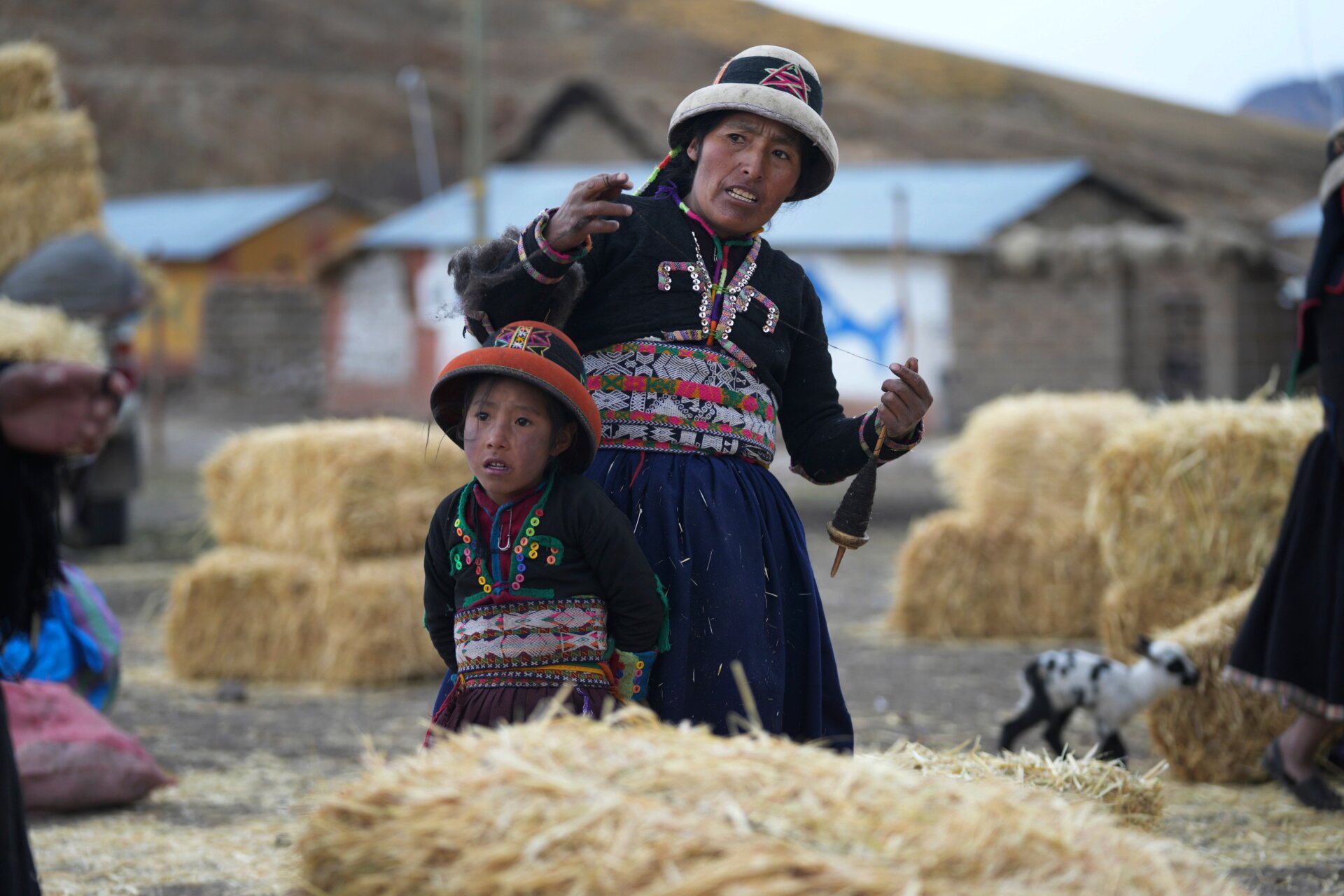 A woman and her daughter stand near feed provided by the government to sustain starving animals. 