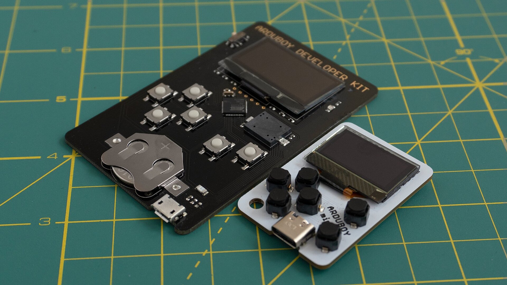 The Arduboy Mini (right) compared to the Arduboy Development Kit (left) which both feature a caseless design with exposed electronics.