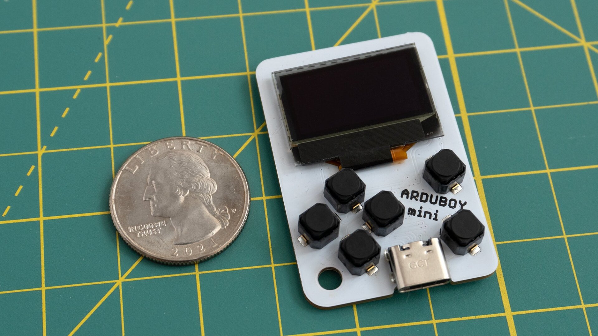 The Arduboy Mini (right) compared to the size of a US quarter (left).