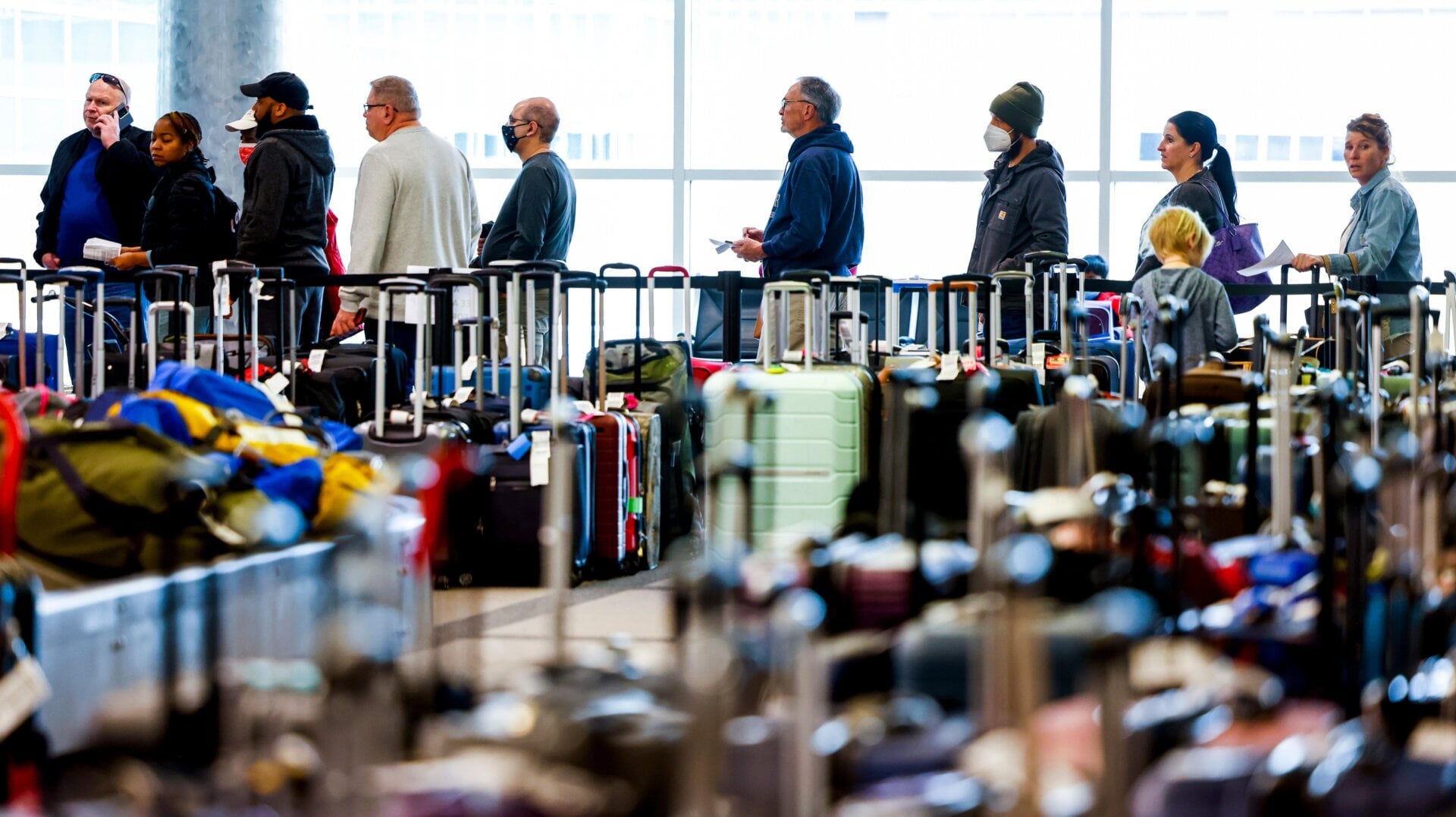 Travelers wait to search for their luggage in a baggage holding area for Southwest Airlines on Dec. 28, 2022.