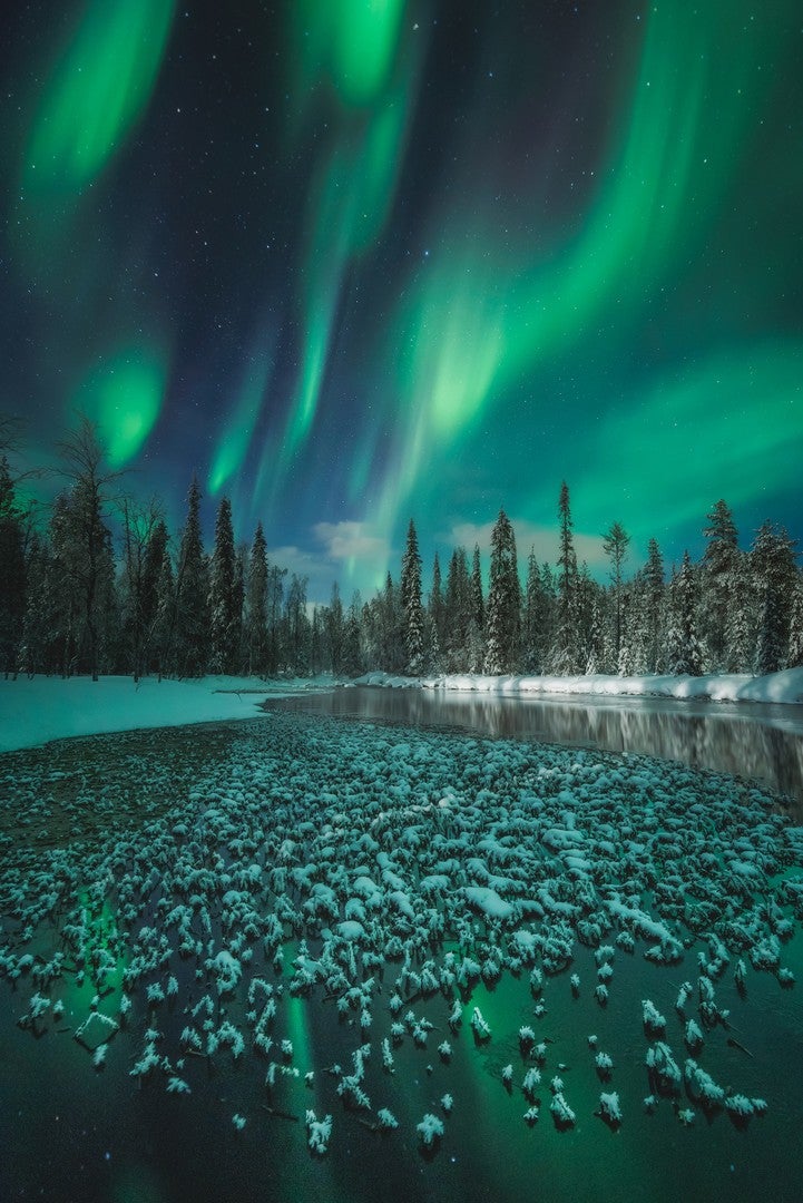 A frozen water body beneath the aurora in Finland.