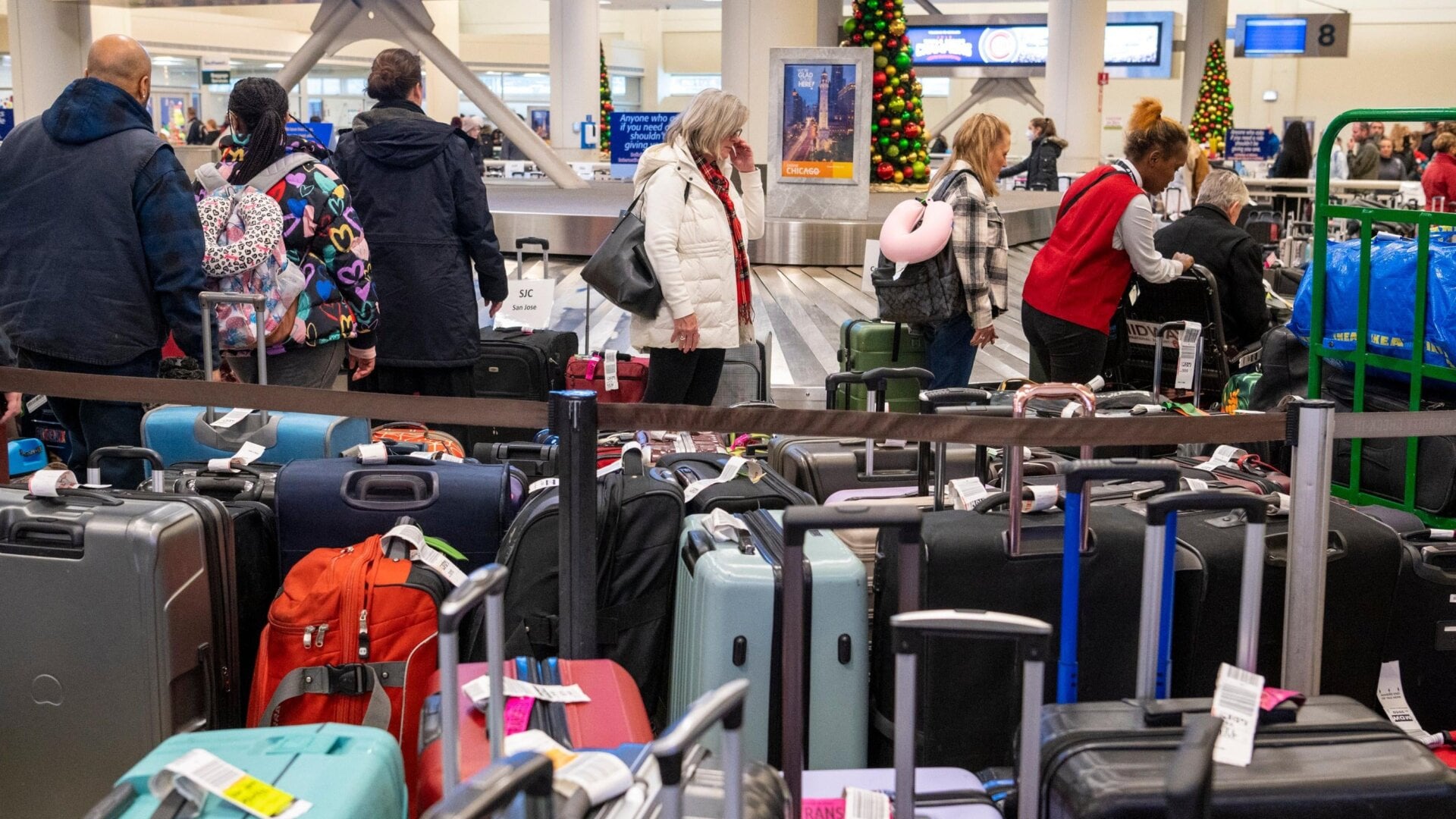 Travelers search through mountains of luggage at the baggage claim at  Chicago Midway International Airport on Dec. 26, 2022, in Chicago.
