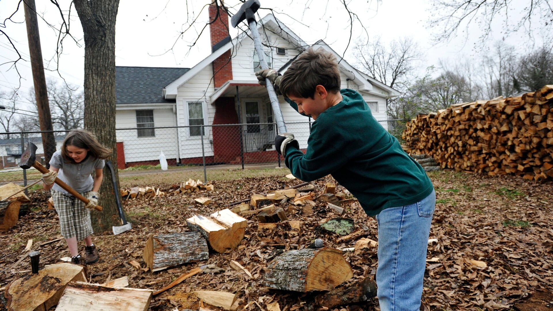 Daniel Overstreet, 9, right, and his sister, Esther Overstreet, 11, chop firewood in their backyard, Tuesday, Dec. 20, 2011, in Greenville, S.C.