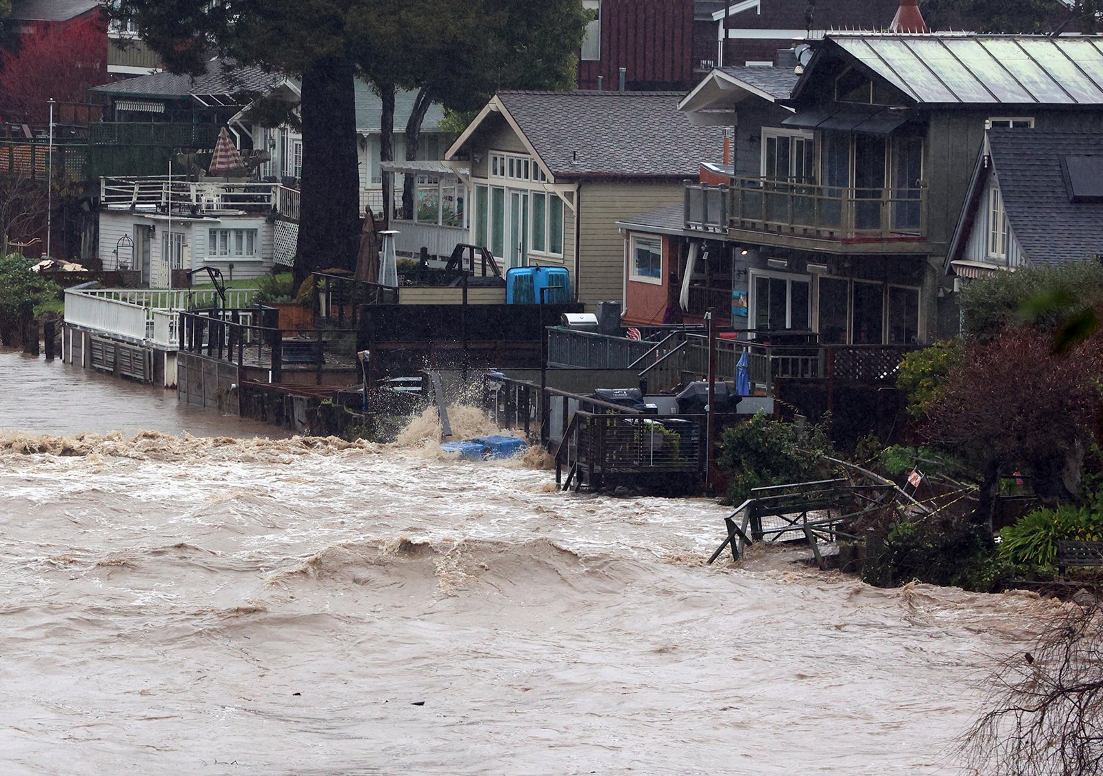 Yards along Soquel Creek in Capitola Village are flooded by storm surge on Thursday, Jan. 5, 2023, in Capitola, California.