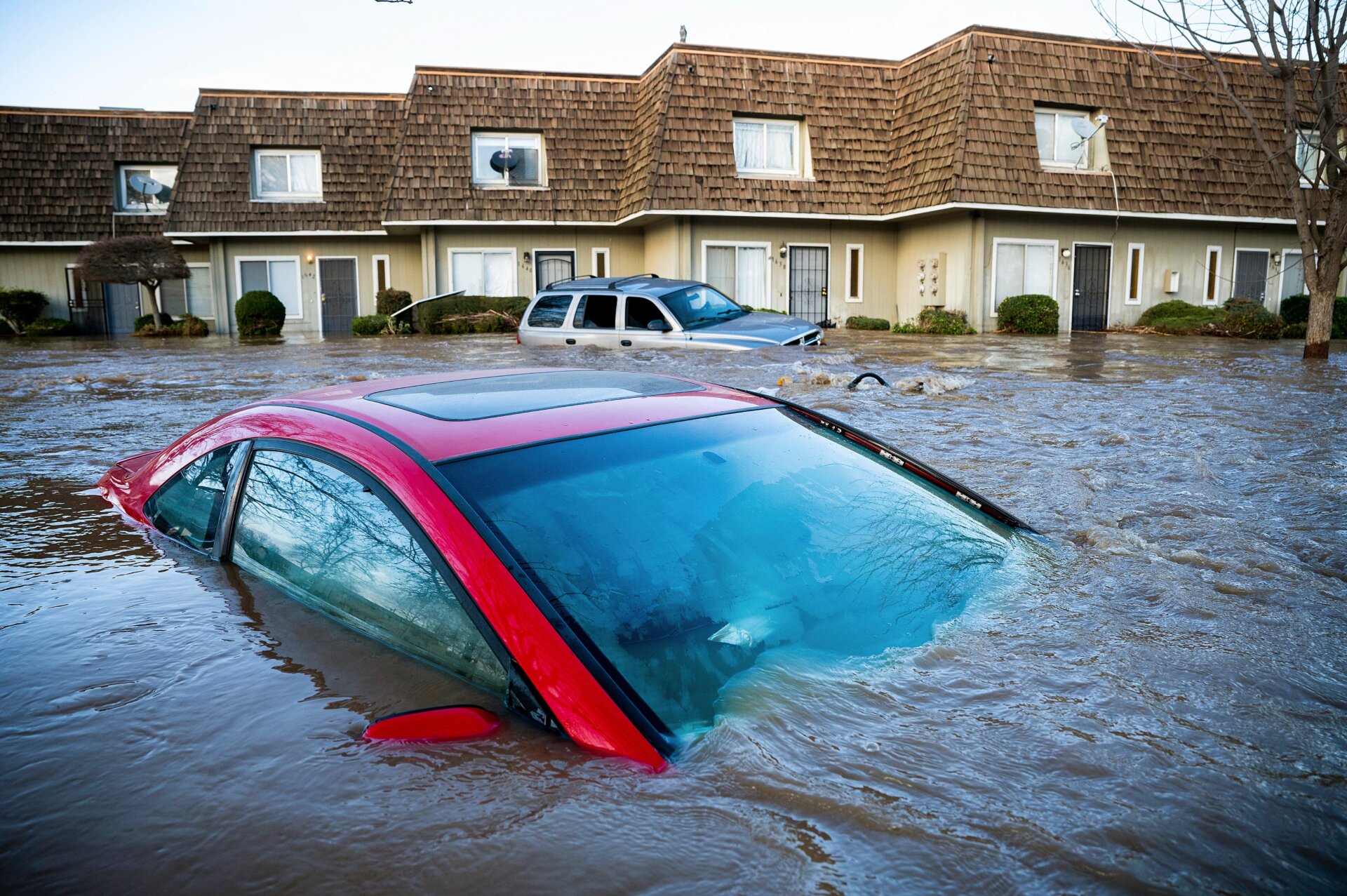 Floodwaters submerge a car in Merced.