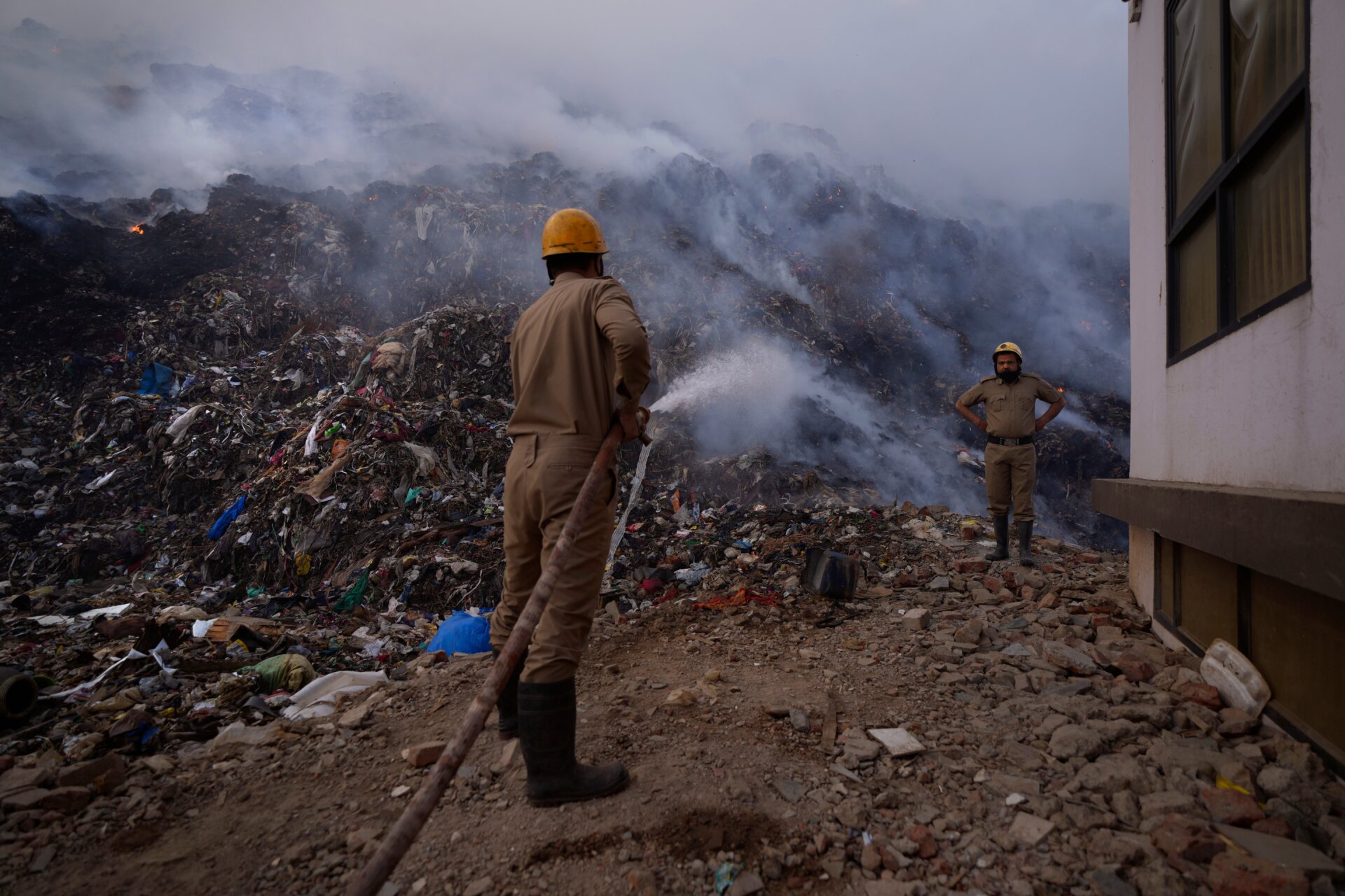 Fire officials try to douse a fire at the Bhalswa landfill in New Delhi, India, Wednesday, April 27, 2022.