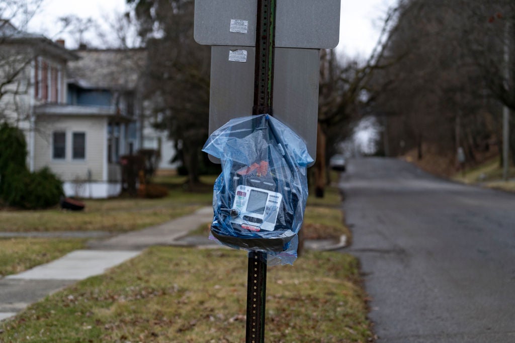 An air quality monitor hangs on a stop sign near the site of the train derailment. 