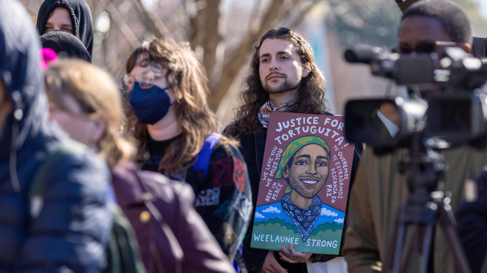 At a February press conference, an attendee holds a sign commemorating slain environmental activist, Manuel “Tortuguita” Paez Terán, who was killed by police in January during ongoing protests.