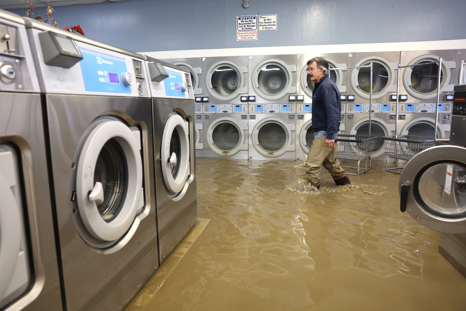 Patrick Cerruti walks through a flooded laundromat in Pajaro on March 14.